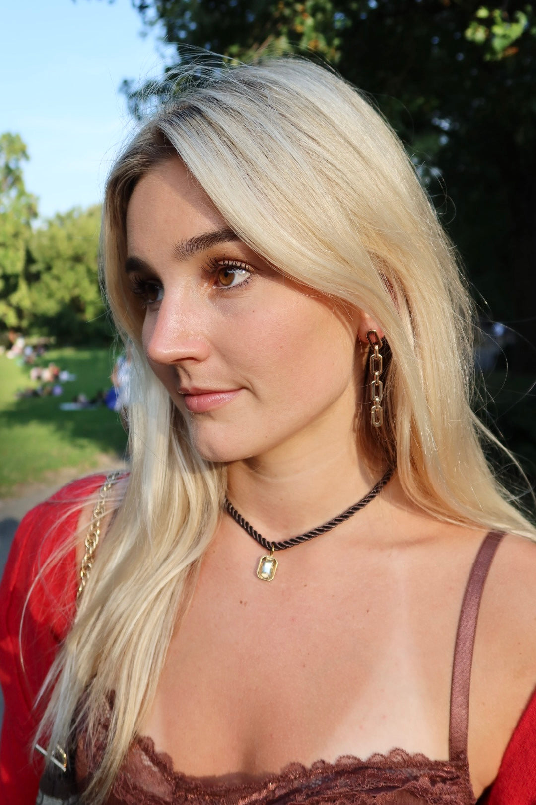 Woman with blonde hair and a red top in an outdoor setting linny co