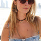 Woman wearing acetate statement earrings and a denim top with a cityscape in the background