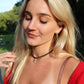 Woman with blonde hair and a red top outdoors wearing a rope gemstone necklaces