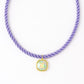 Necklace with a purple cord and a square pendant on a white background