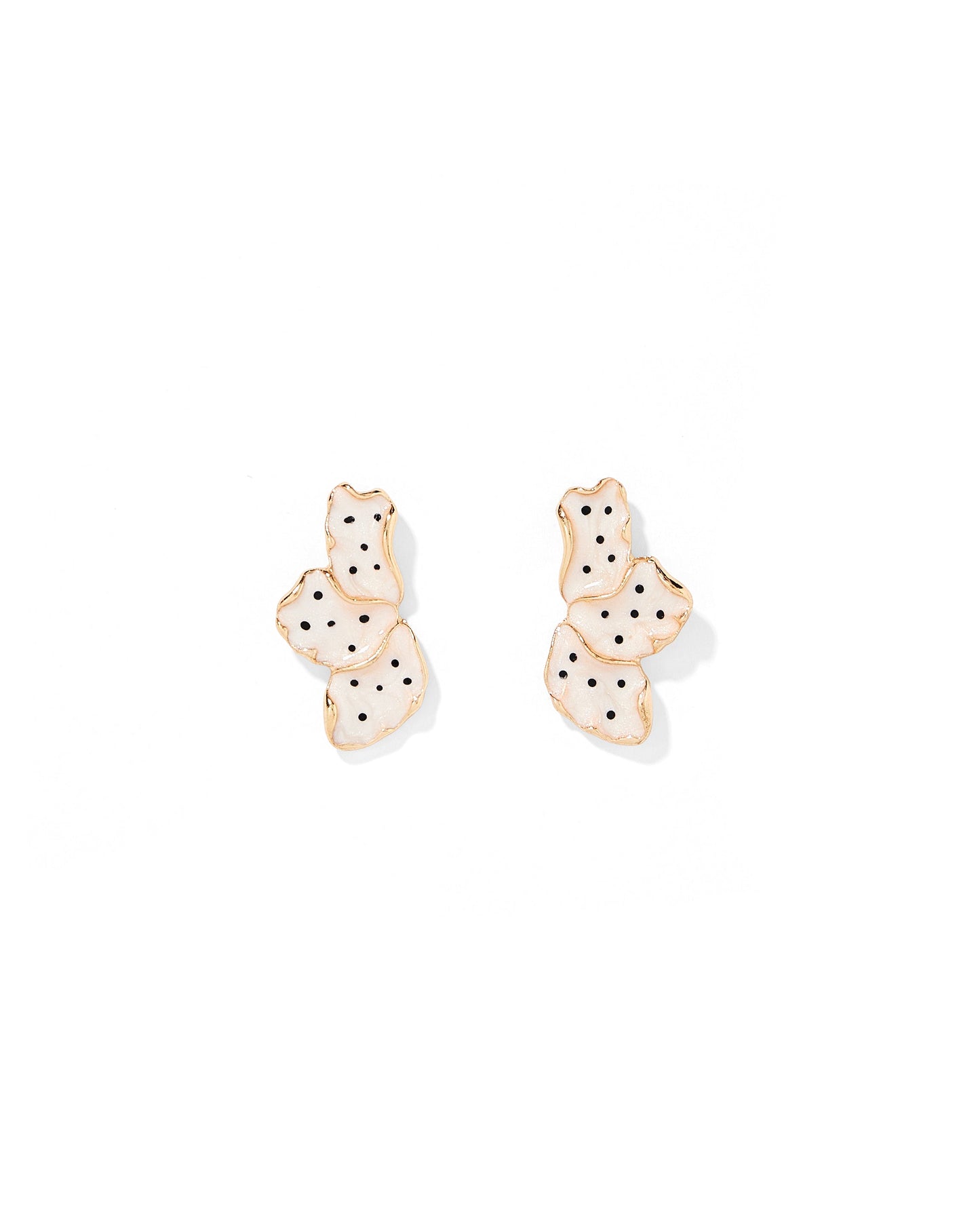 Pair of gold earrings with black polka dots on a white background
