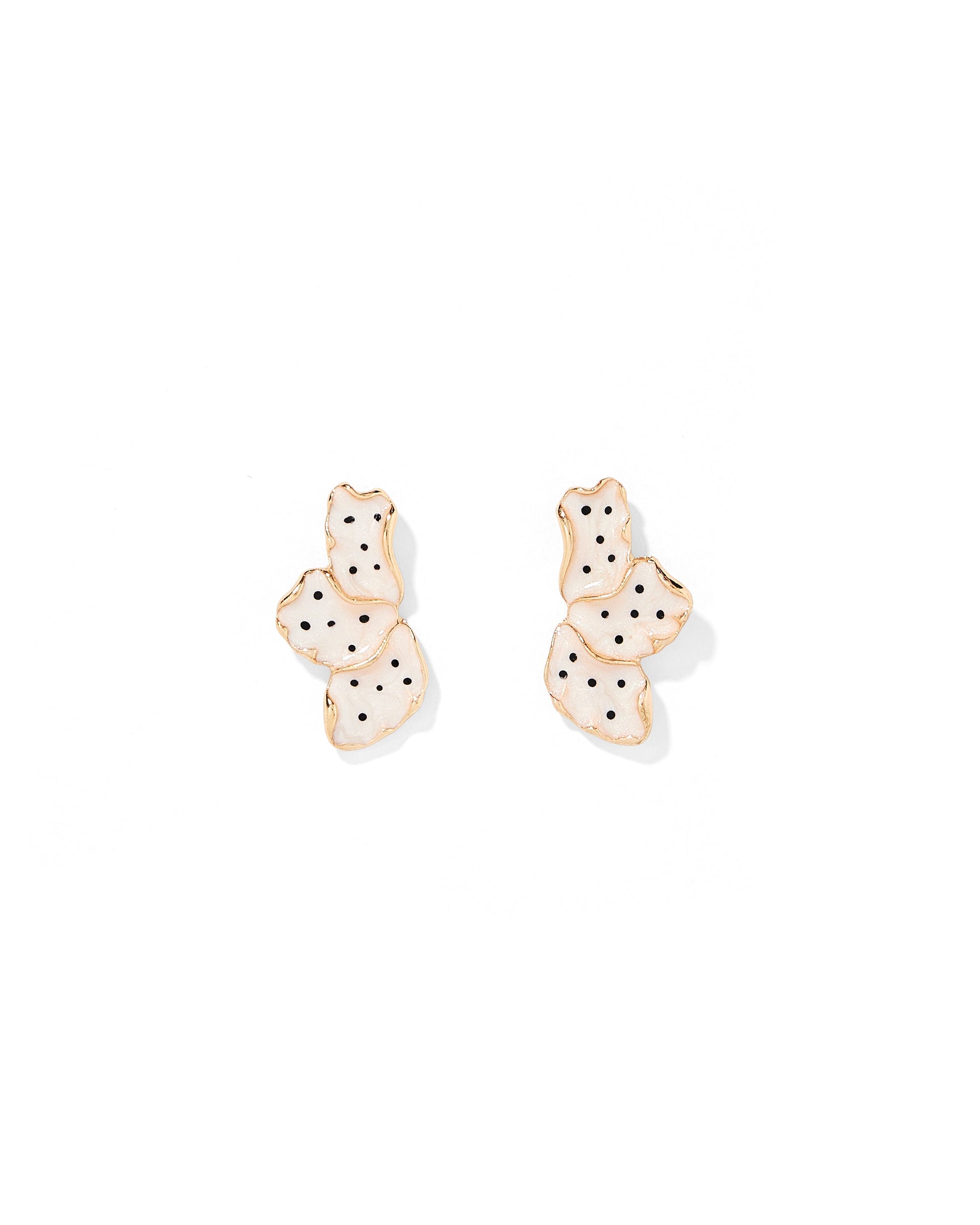 Pair of gold earrings with black polka dots on a white background