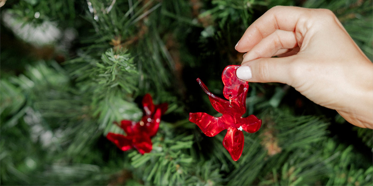 Red LINNY CO statement earrings hanging on a Christmas tree